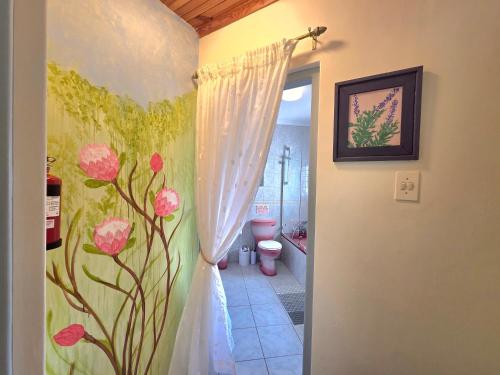 a bathroom with pink flowers painted on the wall at Villa Cape Garden Route in Wilderness