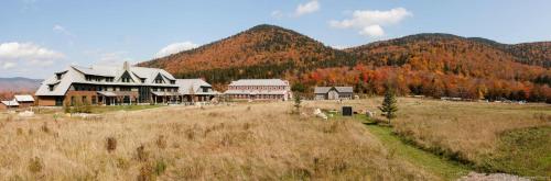 a large building in a field with mountains in the background at Highland Center in Bretton Woods