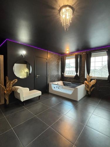a large bathroom with a tub and a mirror at Le Bovary Hotel Suite Diamond in Héron