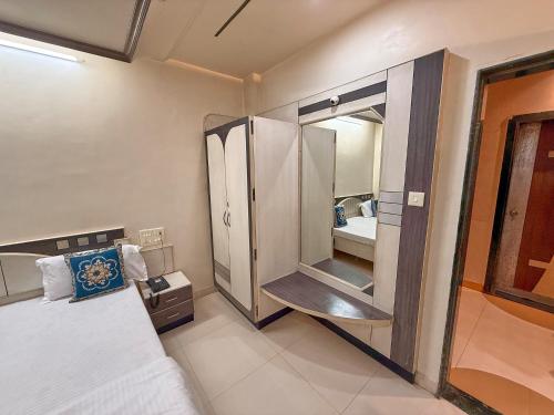 a bedroom with a bed and a large mirror at Hotel Kinara Lodge in Jāmkhed