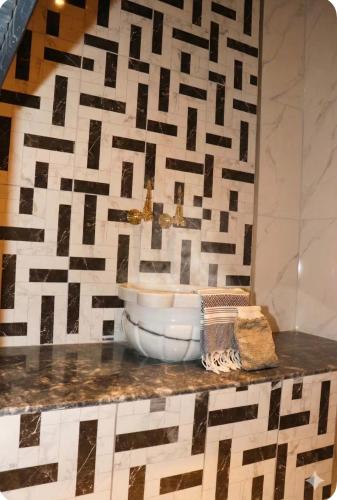 a bathroom with a sink and a mosaic wall at MiNKA HOUSE in Hisarcık