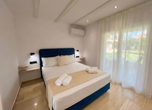a bedroom with a large bed with towels on it at Hestia ApartHotel in Roda