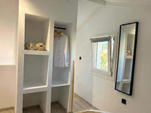 a room with white shelves and a mirror at Hestia ApartHotel in Roda