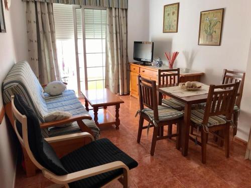 a living room with a table and chairs and a television at Jeribel PlayA1 in Fuengirola