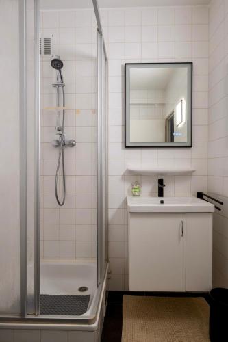 a bathroom with a shower and a sink and a mirror at Appartement Guillaume in Blankenberge