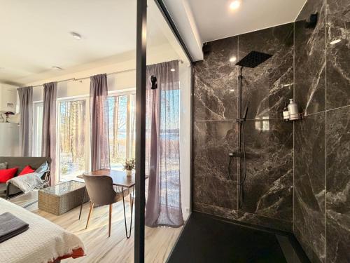 a bathroom with a shower and a bed and a table at Gauja Lakeside in Gauja