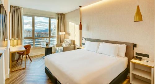 a hotel room with a bed and a desk at Sercotel HMO Martina in Granada