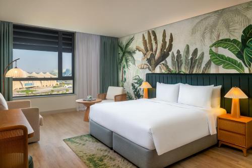 a hotel room with a bed and a large window at Yas Plaza Mangroves by IHG in Abu Dhabi