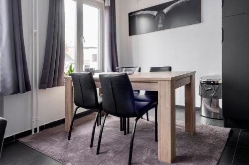 a wooden table with black chairs in a room at Appartement Guillaume in Blankenberge