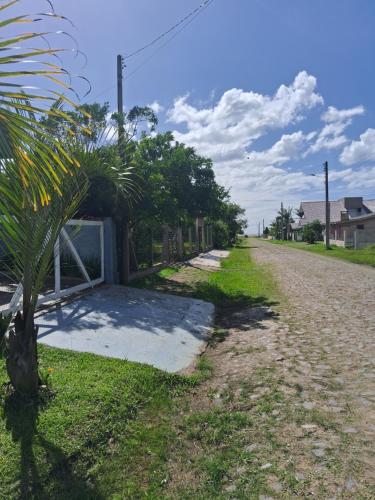 a palm tree on the side of a road at Casa Lovato in Arroio do Sal