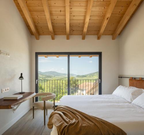ein Schlafzimmer mit Bett, Schreibtisch und einem großen Fenster in der Unterkunft ATEALAIA Kortezubi in Forua