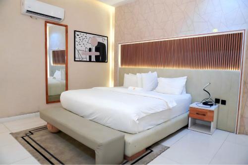 a bedroom with a large white bed and a mirror at 2020 Apartment Guzape in Chini