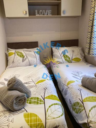 two beds sitting next to each other in a room at Hikers Den, Brigham, Cockermouth, Cumbria in Cockermouth
