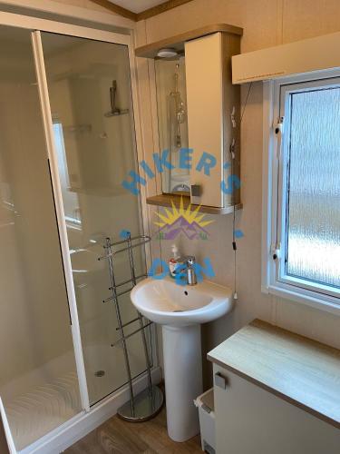 a small bathroom with a sink and a shower at Hikers Den, Brigham, Cockermouth, Cumbria in Cockermouth