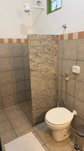 a bathroom with a toilet and a shower at Pousada do Ipe in Goiás