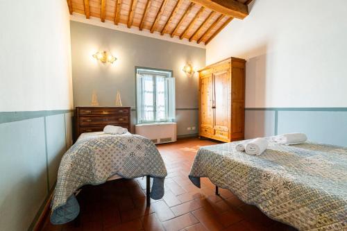 a bedroom with two beds and a dresser and a window at Agriturismo Gli Archi in Fauglia