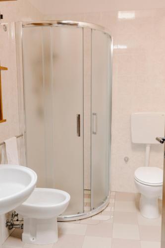 a bathroom with a shower and a toilet and a sink at Villaggio California in Eraclea Mare