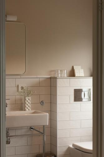 a white bathroom with a sink and a mirror at Sola Strand Hotel in Sola