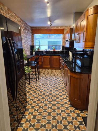 a kitchen with a black and white tiled floor at Charming Mill Cottage Carrickfergus in Carrickfergus