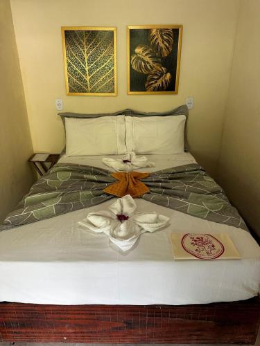 a bedroom with a bed with a flower on it at Pousada Meraki Paraty Mirim in Paraty