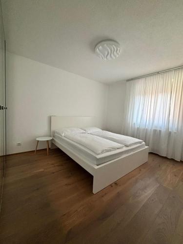 a white bedroom with a bed and a window at Gemütliche Wohnung in Puch in Puch bei Hallein