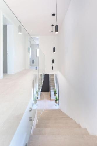 a staircase in a building with white walls and white floors at Luxury villa del Sol in Novalja