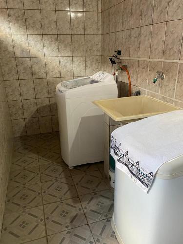 a small bathroom with a washing machine and a tub at Casa no Roteiro do Vinho - Casa 02 in São Roque