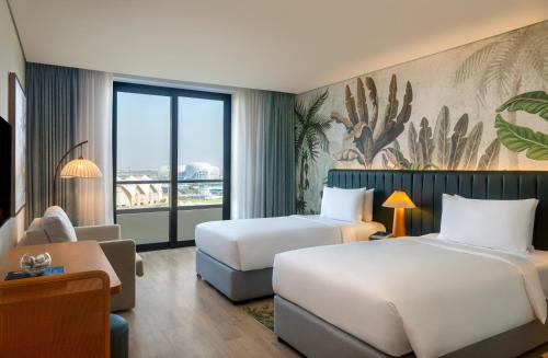 a hotel room with two beds and a couch at Yas Plaza Mangroves by IHG in Abu Dhabi