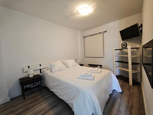a bedroom with a white bed with towels on it at Sunset living area in Puerto de la Madera