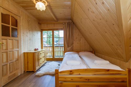 a bedroom with a bed in a log cabin at udanypobyt Domek Przy Lesie in Kościelisko