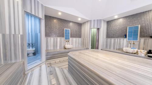 a bathroom with a tub and two sinks and a toilet at Teymur Continental Hotel in Gaziantep