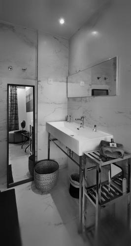 a bathroom with a sink and a mirror at Le Petit Trianon et le Charme des Suites in Nice