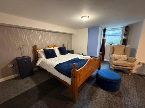 ein Schlafzimmer mit einem großen Bett und einem Stuhl in der Unterkunft Captain Howey Hotel in New Romney