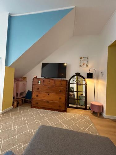 a living room with a tv on top of a dresser at Dolce Faro Niente Guest House in Faro