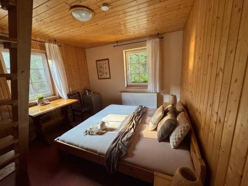 a bedroom with a bed in a wooden room at Kamenný Mlýn in Strážné