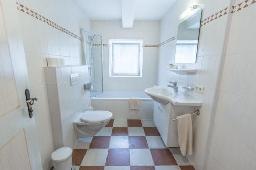 a white bathroom with a toilet and a sink at Ferienhaus/Chalet Schneiderhäusl in Flachau
