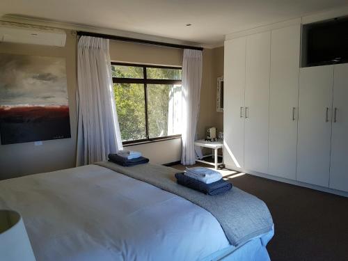 a bedroom with a large bed and a window at Seaside Hermanus Guest Room in Hermanus