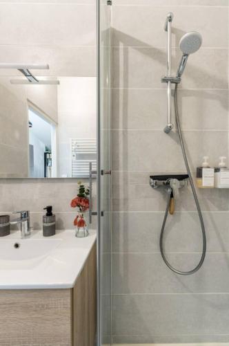 a bathroom with a shower with a glass door at le karibu appartement confort tout équipé in Lagnieu