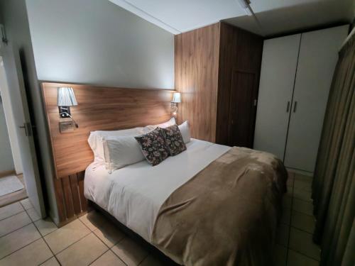 a bedroom with a large bed with a wooden headboard at Flat 1 in Kimberley