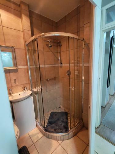 a shower with a glass door in a bathroom at Flat 1 in Kimberley