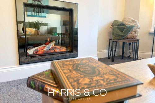 a stack of books sitting on a table in front of a fireplace at Driftwood Bay in Fleetwood
