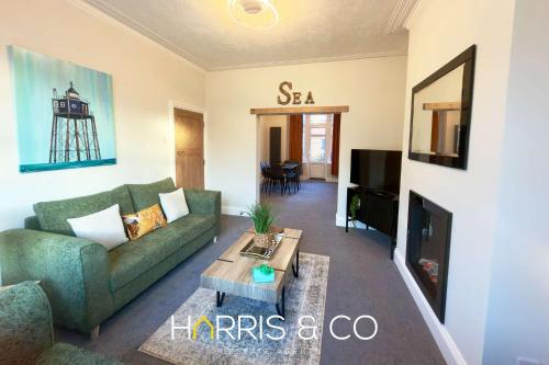 a living room with a couch and a table at Driftwood Bay in Fleetwood