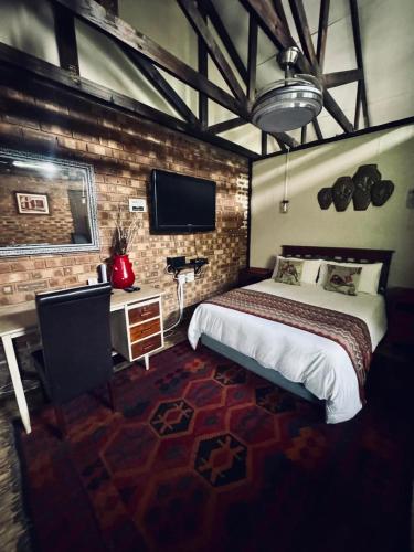 a bedroom with a bed and a desk and a television at Revenir in Middelburg