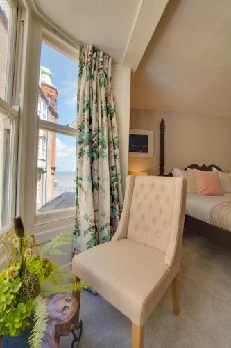 a bedroom with a bed and a window and a chair at 4 Bed in Cromer oc-2117 in Cromer