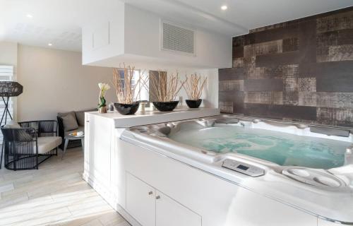 a hot tub in a white kitchen with a table at Best Western Plus Villa Saint Antoine Hotel & Spa in Clisson