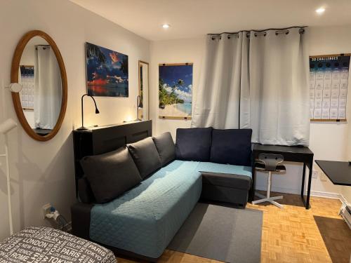 a living room with a blue couch and a mirror at Montreal Hideaway in a Residential area in Montreal