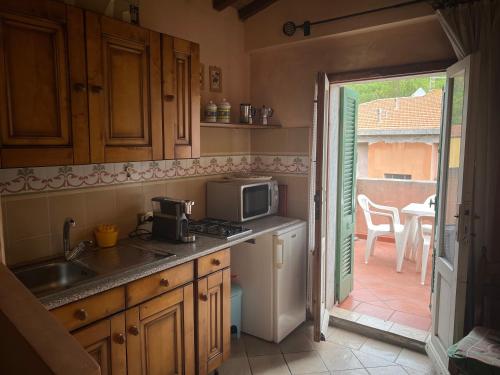 a kitchen with a sink and a microwave at Appartamento e Mansarda al mare in Rio Marina