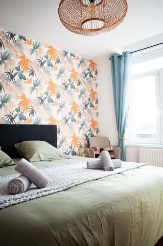 a bedroom with a large bed with a floral wallpaper at Have a Cosy, Élégance in Grand-Fort-Philippe