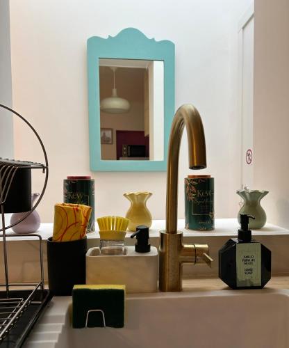 a kitchen sink with a faucet and a mirror at Dolce Faro Niente Guest House in Faro