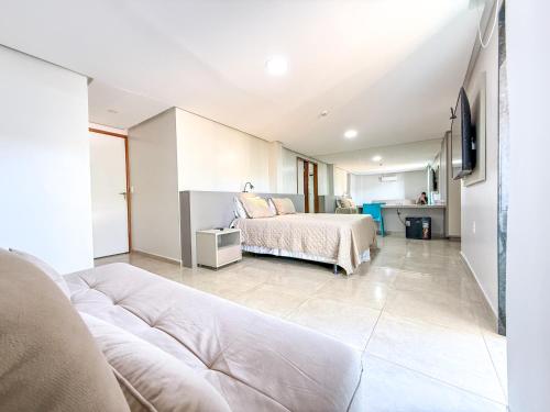a bedroom with a bed and a couch in a room at Hotel JD in Taquaritinga do Norte